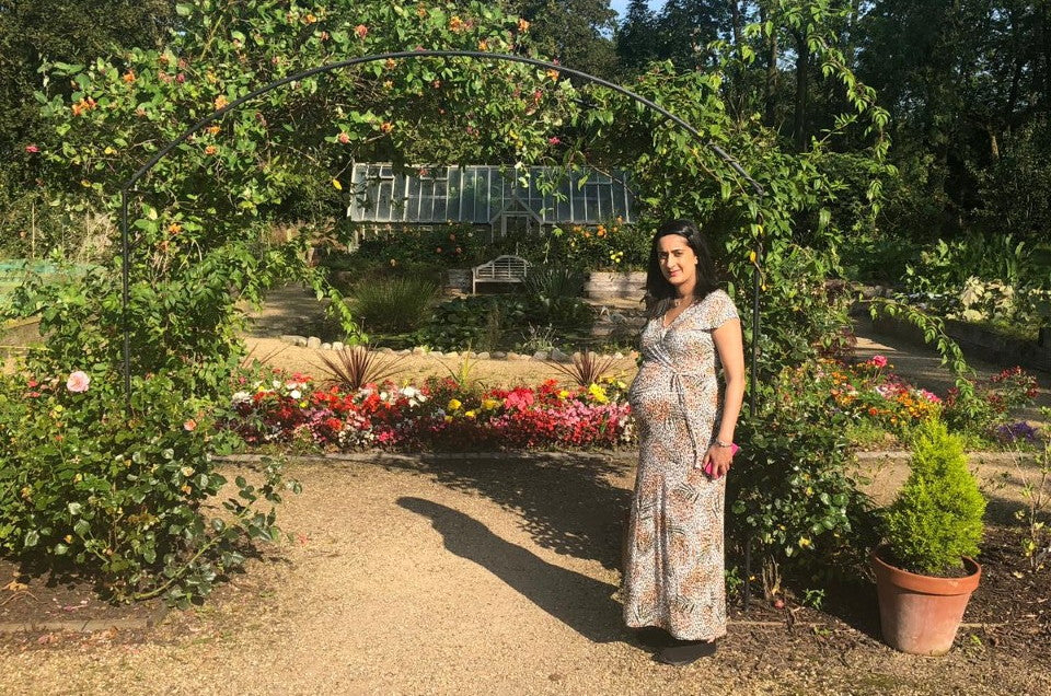 Photo of Amreet in a garden while she's pregnant.